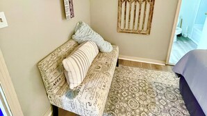 Une pièce chaleureuse avec un canapé à motifs, une étagère décorative et un tapis à motifs.