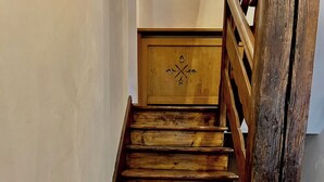 Una escalera de madera con barandilla y un panel decorativo en la parte superior.