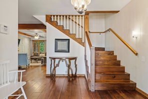 A wooden staircase with a white railing leading to an upper floor.