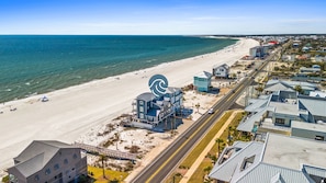 An aerial view of a coastal area with a beach, a large building with a wave symbol, and several other structures. - Beachfront Duplex Unit, Pet Friendly, Mexico Beach, Gorgeous Views! (Mexico Beach)