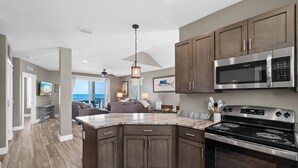 A modern kitchen with dark wood cabinets, a stainless steel microwave, and a built-in oven. - Beachfront Duplex Unit, Pet Friendly, Mexico Beach, Gorgeous Views! (Mexico Beach)