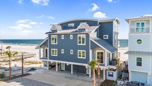 A two-story beachfront house with a wrap-around porch, a covered patio, and a view of the ocean. - Beachfront Duplex Unit, Pet Friendly, Mexico Beach, Gorgeous Views! (Mexico Beach)