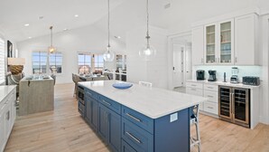 A spacious kitchen with a large island, white cabinetry, and modern appliances. - Estate Home: Gulf Views, Private Pool, Pool Table, Sleeps 20! (Mexico Beach)