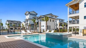 Ein modernes Hotel mit Poolbereich, mehreren Etagen und blauem Himmel.