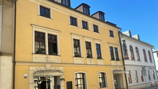 Un bâtiment jaune avec de nombreuses fenêtres et une enseigne indiquant qu’il s’agit d’un hôtel.