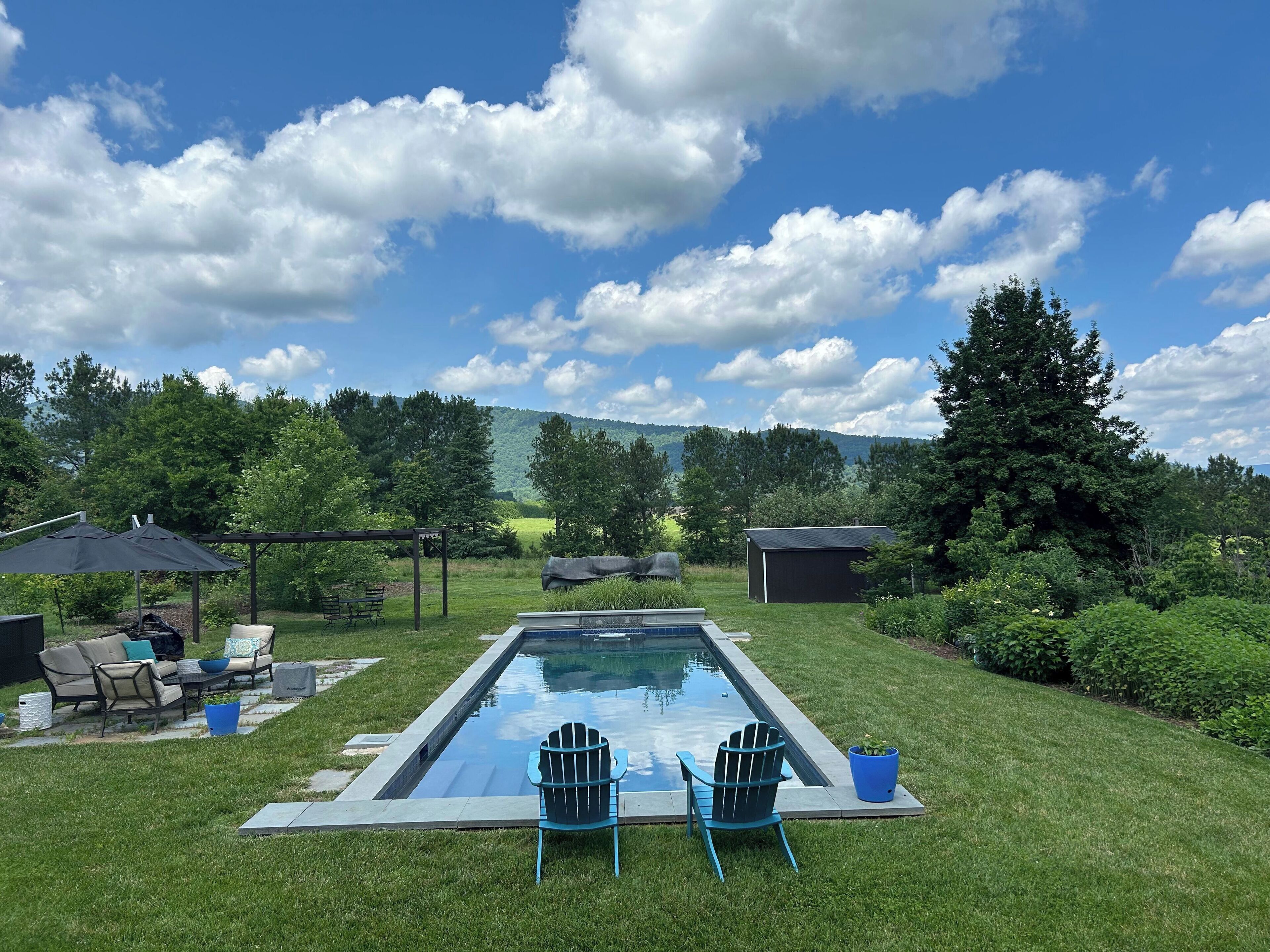 In-ground pool has an electric cover, plenty of chairs and mountain views!