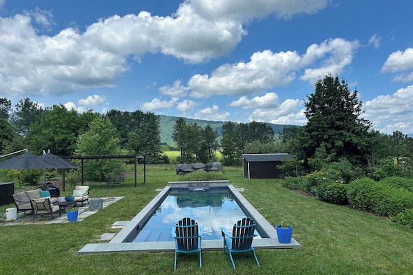 In-ground pool has an electric cover, plenty of chairs and mountain views!