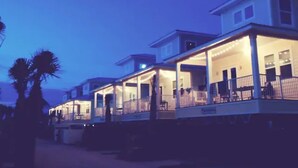 A beachfront property with multiple houses connected by a covered walkway. - Beach Retreat | Pool + Steps to Sand (Gulf Shores)