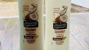 Dos botellas de acondicionador y champú de coco Alberto Balsam sobre una superficie de madera.