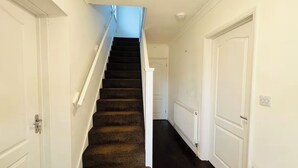 Una escalera con peldaños alfombrados que lleva a una puerta en la parte superior.