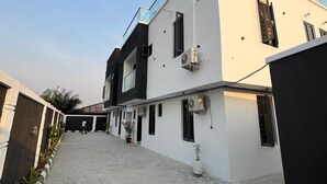 Um edifício moderno de dois andares com telhado plano e varanda.