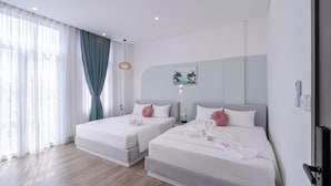 A hotel room with two beds, a large window with sheer curtains, a painting on the wall, and a wooden floor. - Osen Hotel - Grand World Phu Quoc (Phu Quoc)