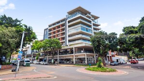 Hotel com vários andares, varandas, um pátio central e diversas lojas no andar térreo.