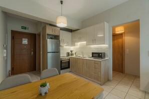 A modern kitchen with a wooden dining table, built-in appliances, and a small potted plant.