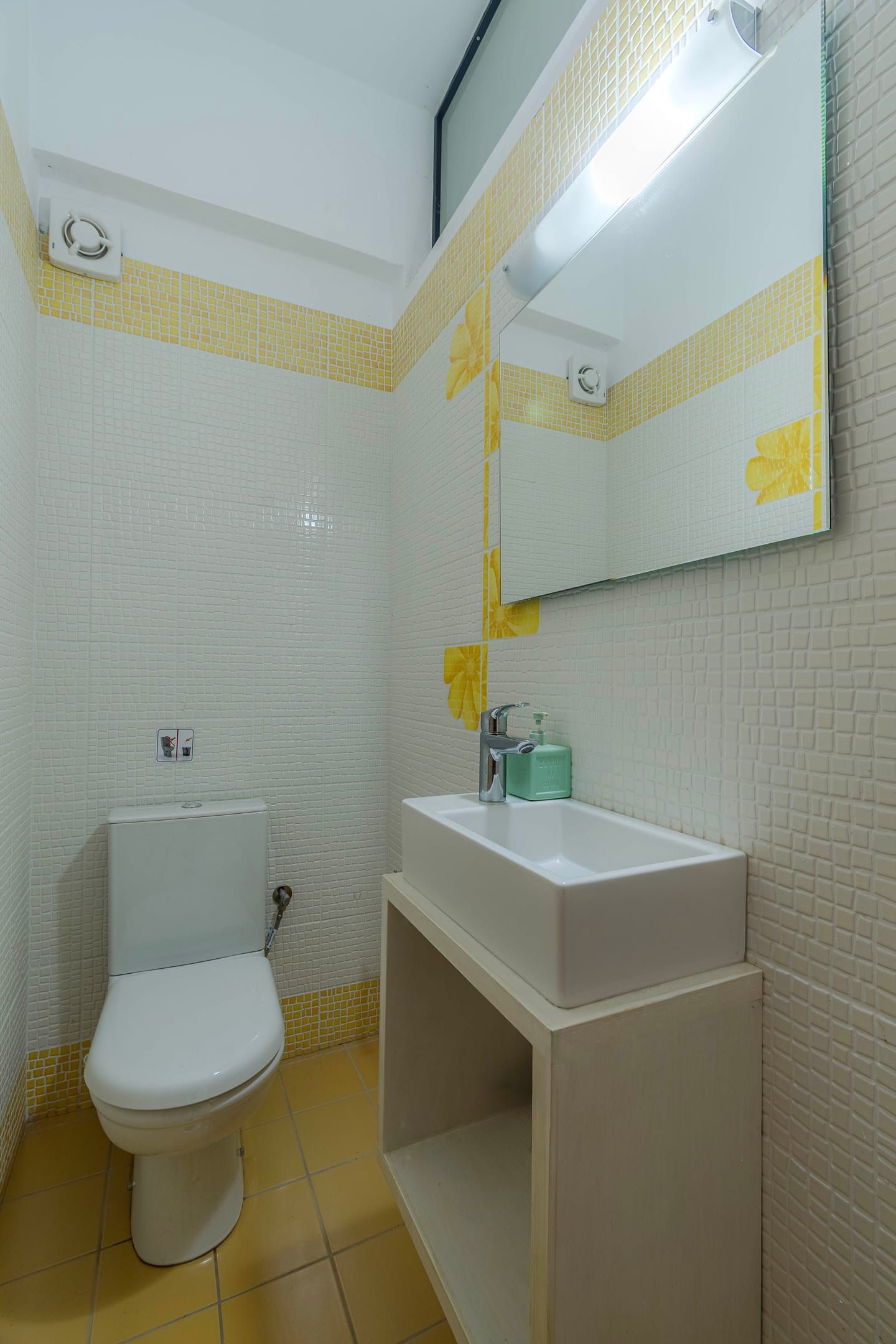 A small bathroom with a toilet, sink, and mirror.