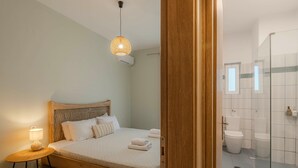 Un dormitorio con cama de madera, lámpara de noche y lámpara colgante.