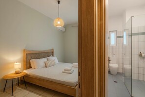 A bedroom with a wooden bed, a bedside lamp, and a hanging light fixture.