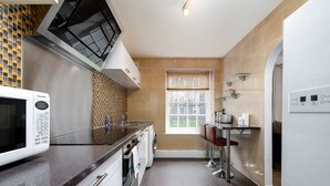 Una cucina moderna con forno a microonde, lavello e finestra con persiane.
