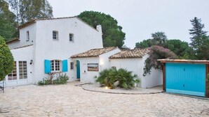 A white building with blue shutters and a stone courtyard. - Villa with swimming pool walking distance from the beach (Ramatuelle)