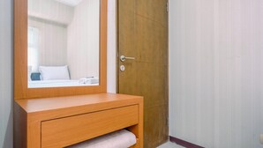Un tocador de madera con espejo, una toalla y una puerta con pomo.