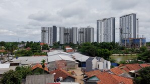 A residential area with multiple high-rise buildings and smaller houses. - Brand New And Super Cozy Studio Room At Sky View Apartment (South Tangerang)