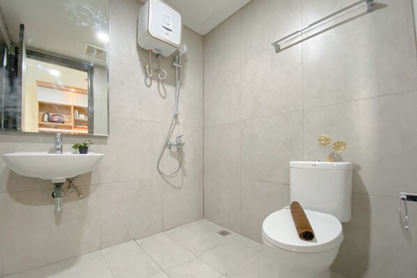 A bathroom with a sink, toilet, and shower. - Convenient And Tidy Studio At Pollux Chadstone Apartment (Cikarang)