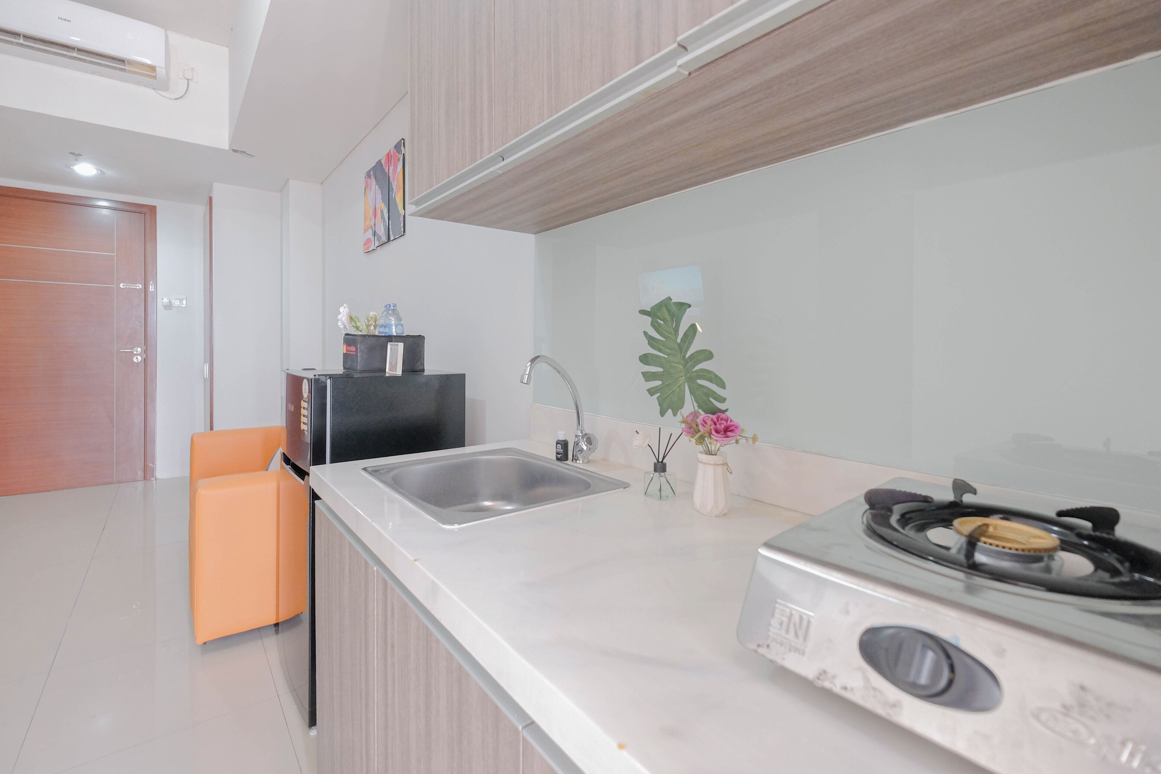 Una cocina moderna con un lavamanos de acero inoxidable, una estufa a gas y una pequeña área de encimera.