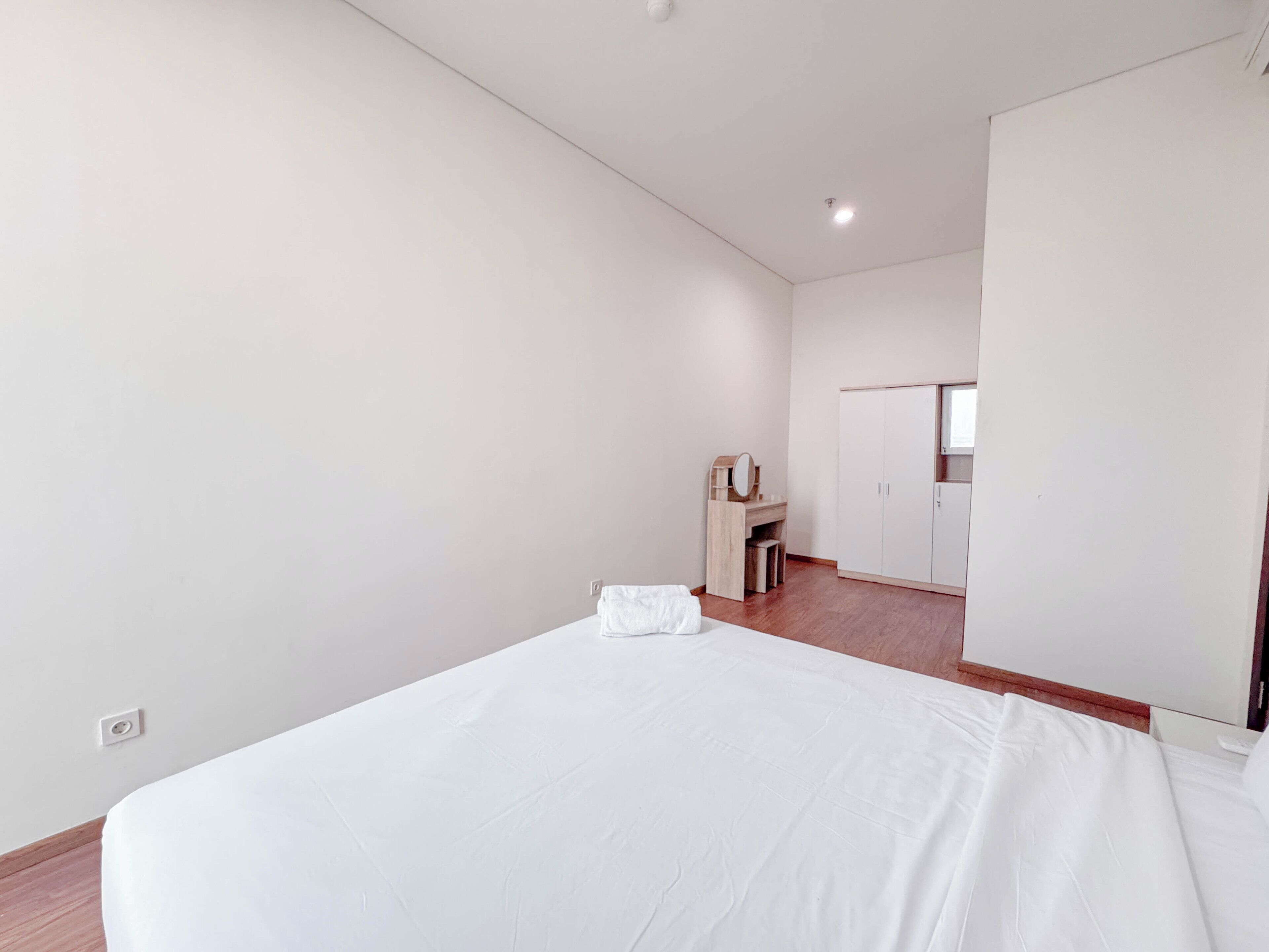 Una camera da letto con un letto grande, una cassettiera in legno, uno specchio e un armadio.