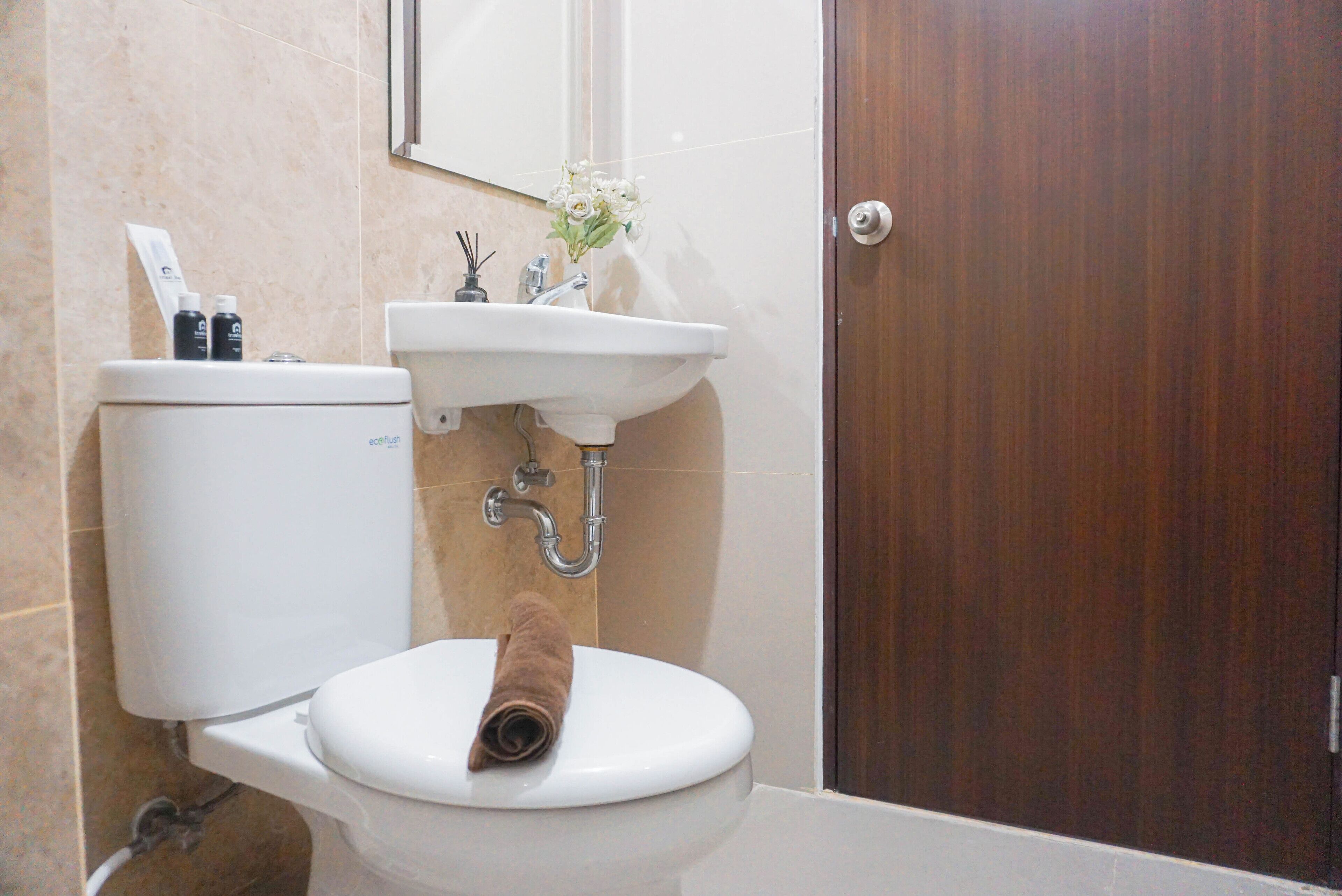 A bathroom with a toilet, sink, and a wooden door.