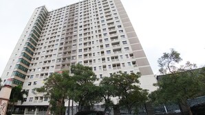 A tall residential building with multiple balconies and a gated entrance. - Lovely 2Br Apartment At Belmont Residence Puri (Jakarta)