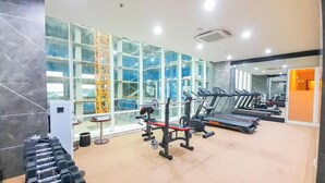 A gym with treadmills, weight machines, and dumbbells. - Relaxing And Stylish Studio At Mataram City Apartment (Ngaglik)