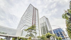 Two high-rise buildings with modern architecture, featuring reflective glass facades and a clear sky. - Relaxing And Stylish Studio At Mataram City Apartment (Ngaglik)