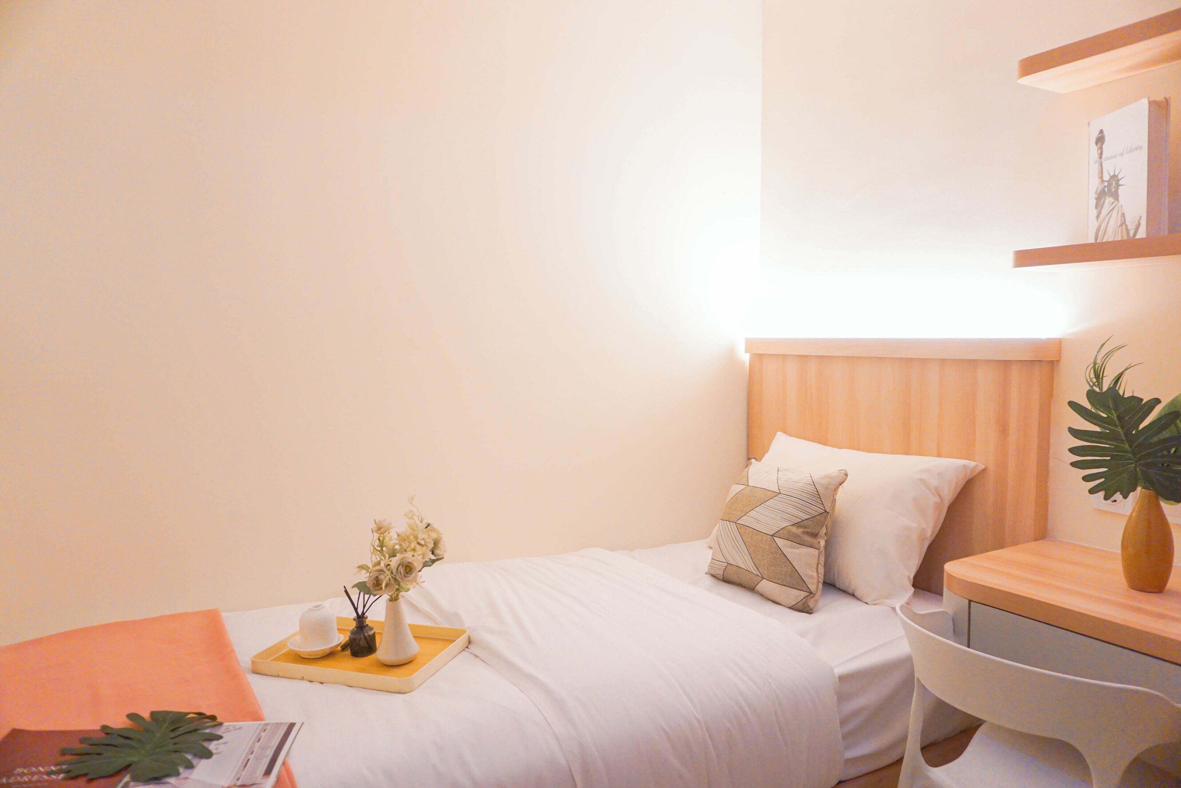 Une chambre d’hôtel bien aménagée, avec un lit, une table de chevet et un petit bureau.