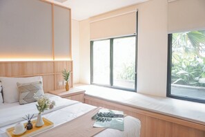 Une chambre moderne avec un grand lit, des tables de chevet, une fenêtre donnant sur un paysage verdoyant et une plante placée sur une table de chevet.