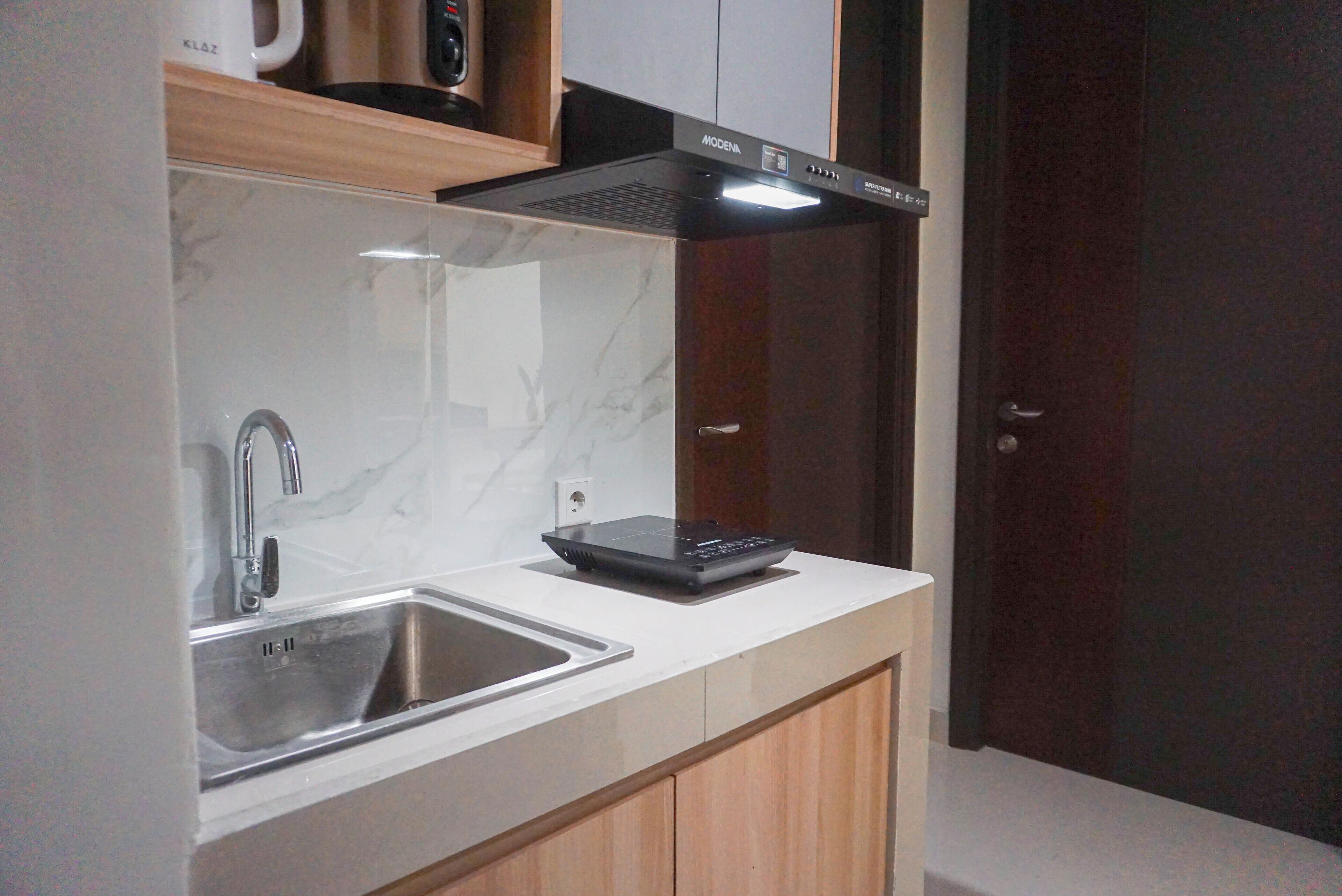 A modern kitchen with a built-in stove, a sink, and wooden cabinets.