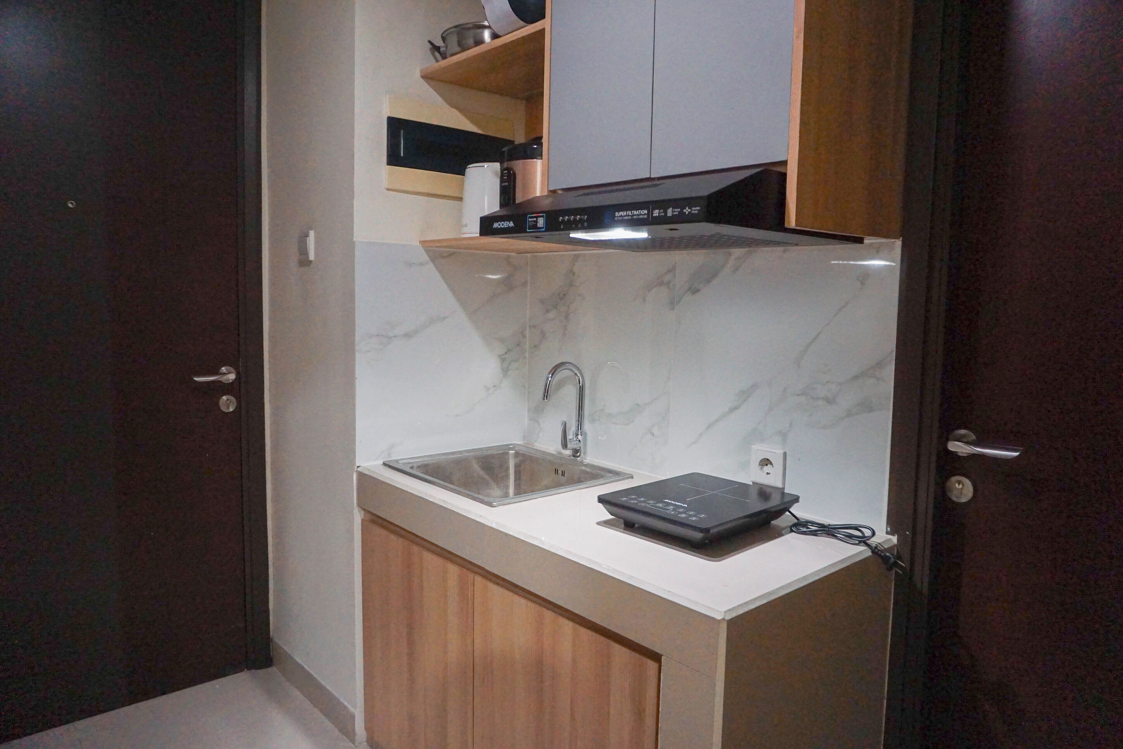 Una cucina compatta con un piano di lavoro in marmo, un lavello e un forno a incasso.