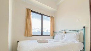 A single bed with a headboard, a window with curtains, and a view of the sky. - Scenic View 2Br At Apartment Tamansari Panoramic (Bandung)
