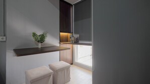 A modern room with a built-in bench, a small table, and a potted plant. - Comfy And Well Studio At Tokyo Riverside Pik 2 Apartment (Teluknaga)