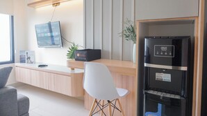 Una recepción con un televisor de pantalla plana, una bolsa de viaje negra y un dispensador de agua.