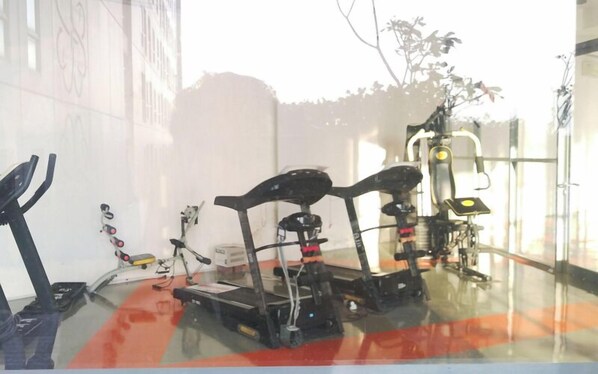 Un gimnasio con equipo de ejercicio, incluyendo cintas de correr y máquinas de pesas.