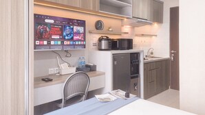 Eine moderne Küche mit integriertem Fernseher, der einen Film zeigt, inklusive Kühlschrank, Mikrowelle und Spüle.