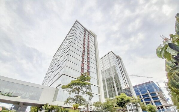 Two high-rise buildings with modern architecture, featuring reflective glass facades and a clear sky.
