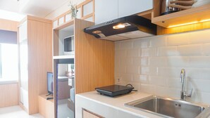 A modern kitchen with wooden cabinets, a stainless steel sink, and a built-in microwave.