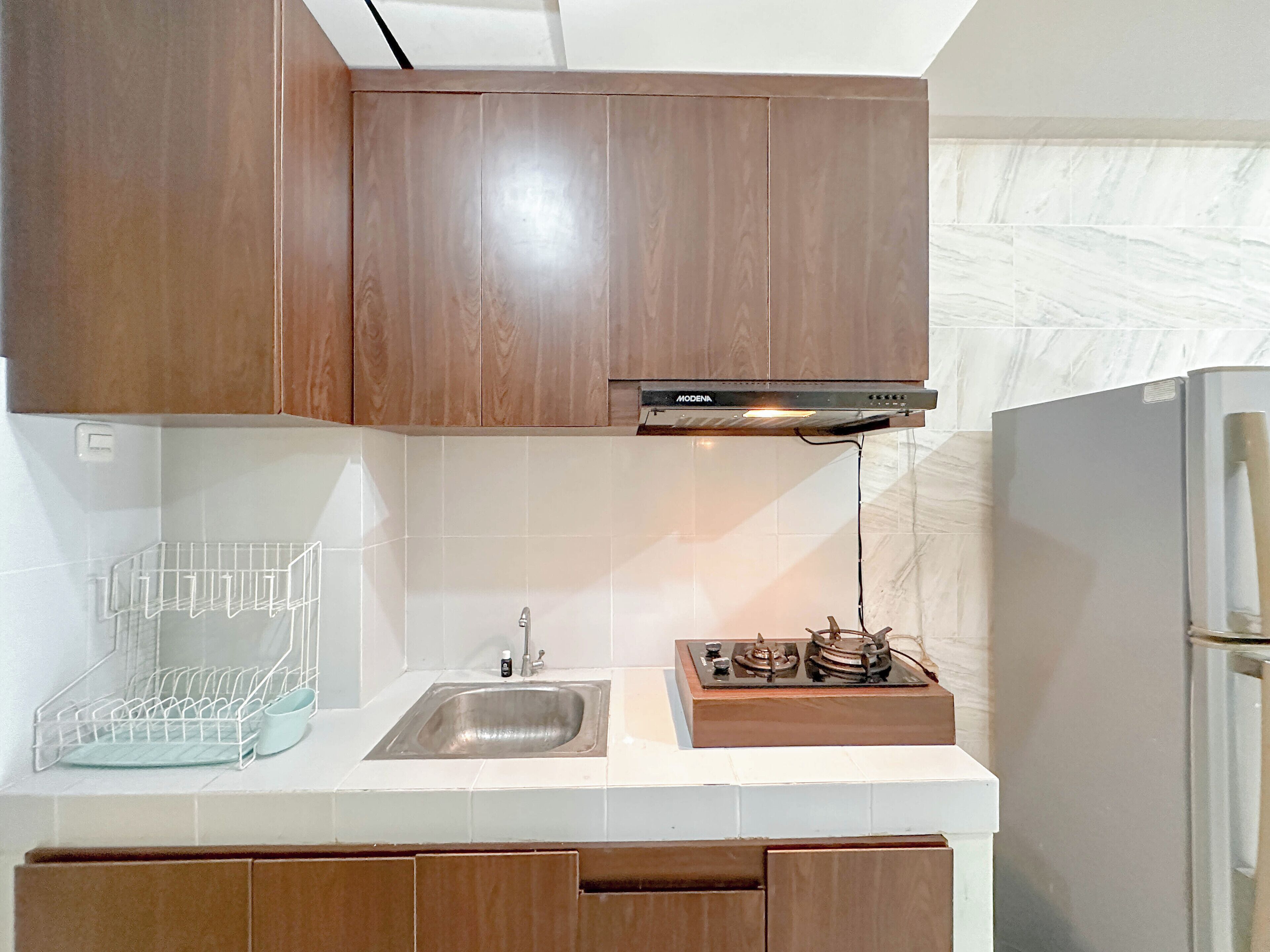 A kitchen with wooden cabinets, a stainless steel sink, and a built-in stove.