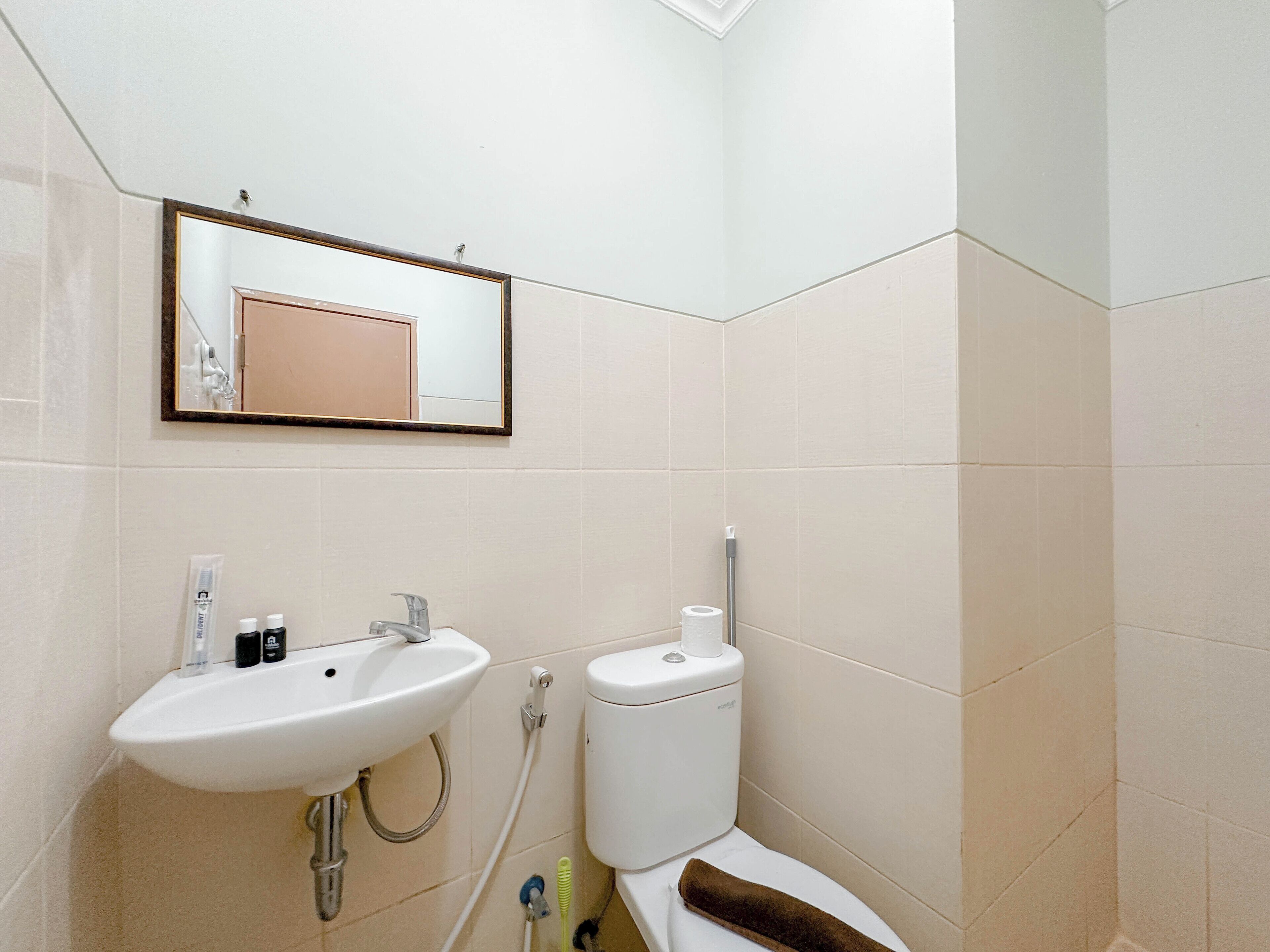 A bathroom with a white sink, mirror, and toilet.