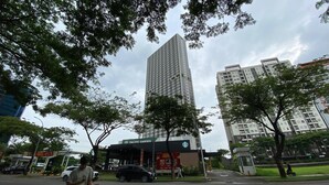 A tall building with a Starbucks sign, surrounded by trees and other buildings. - Good Studio Near Binus At Pacific Garden Apartment (Tangerang)