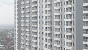 A high-rise building with multiple balconies and windows. - Good Concept Studio At Tanglin Supermall Mansion Apartment (Surabaya)
