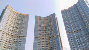 A high-rise building with a curved facade, multiple floors, and a clear sky in the background.