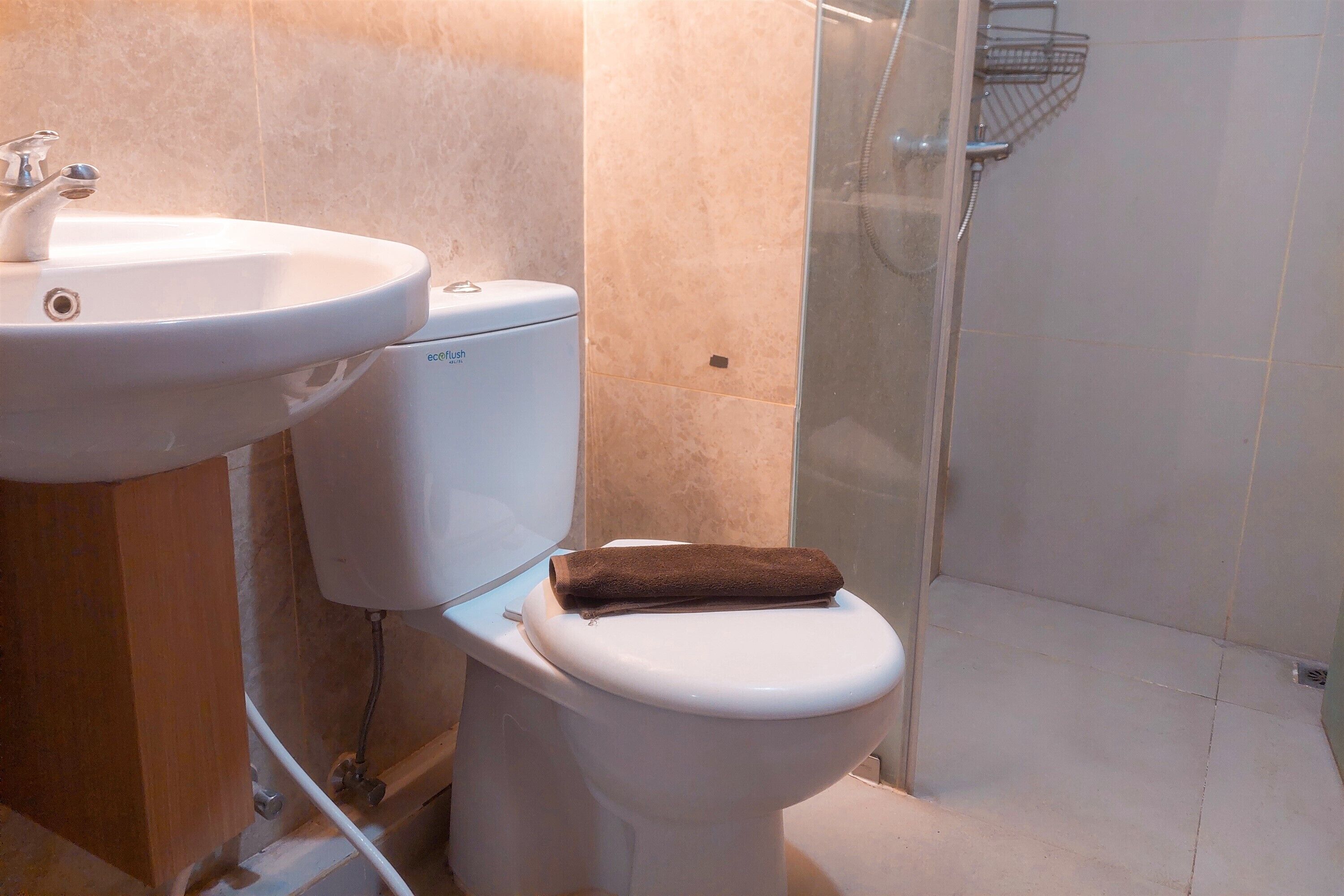A bathroom with a white sink, toilet, and shower.