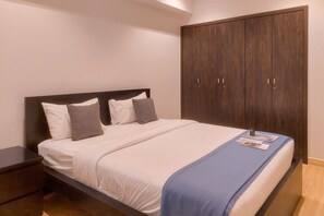 A bedroom with a bed, a nightstand, and a wardrobe. - Elegant 1Br Apartment At Branz Bsd City (Pagedangan)